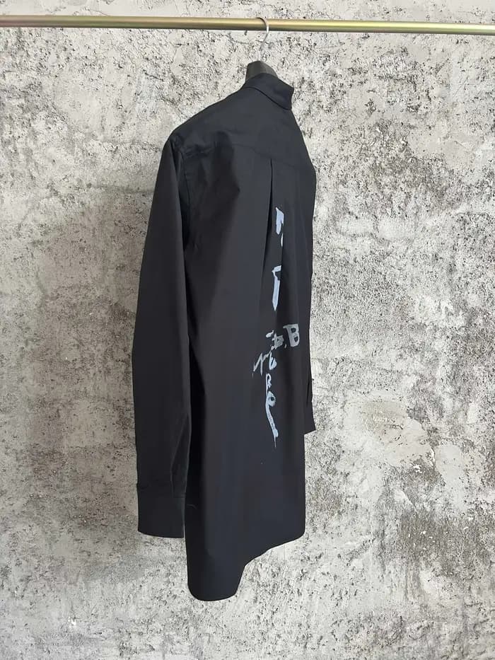 Une simple chemise simple boutonnage à manches longues avec un col double couche, couleur unie et de
