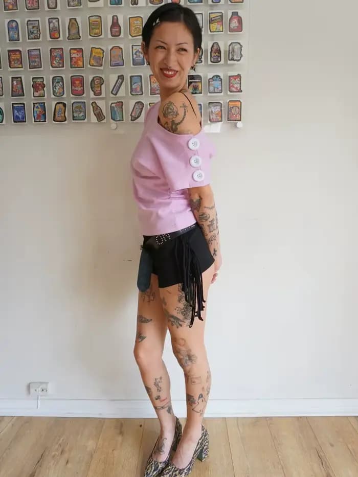 T-shirt rose à épaules dénudées pour femme avec encolure asymétrique et détail boutonné sur la manche