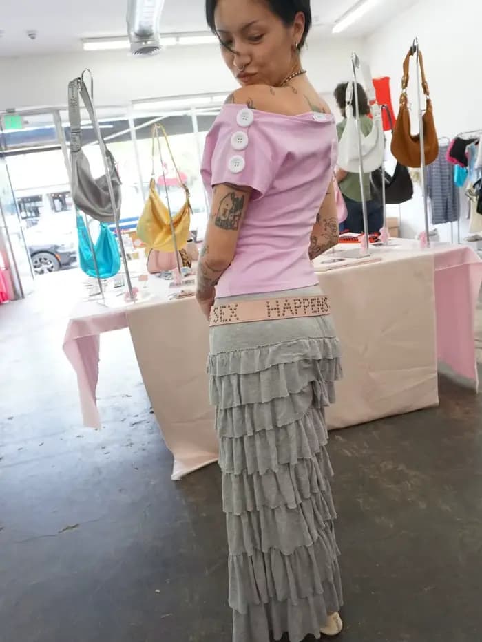 T-shirt rose à épaules dénudées pour femme avec encolure asymétrique et détail boutonné sur la manche